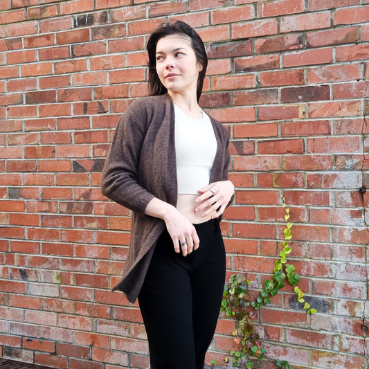 Black haired woman wearing knitted Cardigan in a rich chololate brown colour. Cardi made from Merino Possum and Silk. Knitted locally in New Zealand by an Ethical, sustainable female designer. cardigan has a open front, mid hip length and three quarter long sleeves