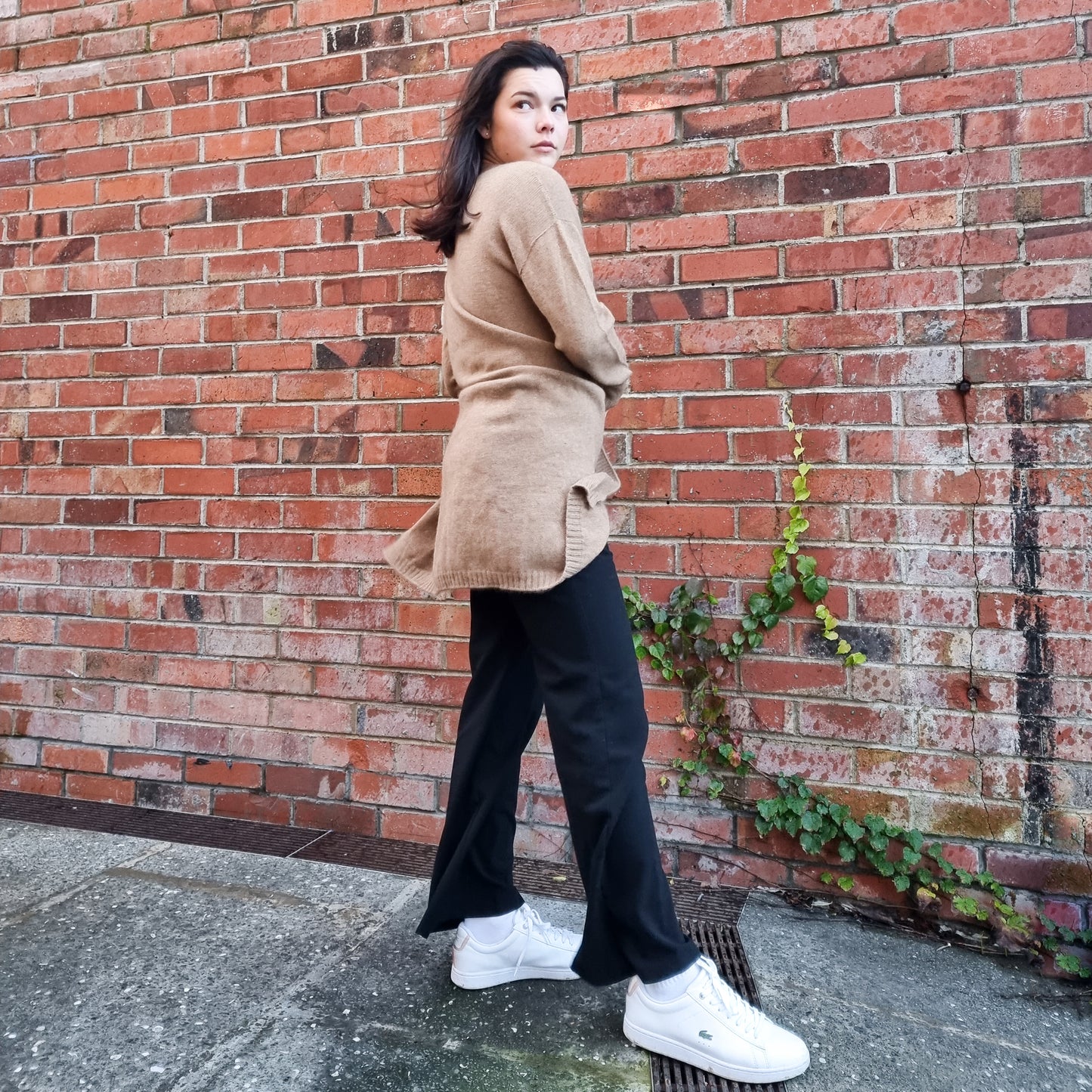 Black haired woman wearing knitted Cardigan in a caramel brown colour. Cardi made from Merino Possum Angora and Silk. Knitted locally in New Zealand by an Ethical, sustainable female designer. cardigan has a open front, mid thigh length and long sleeves