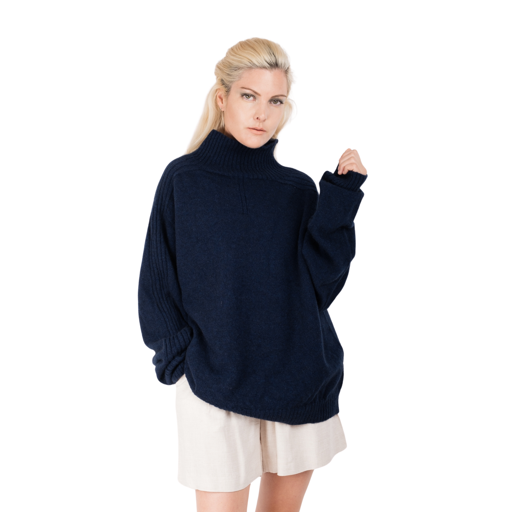 Blonde Woman wearing a deep ink blue oversize turtleneck sweater made from Merino possum and Nylon. Jumper made in New Zealand by a female designer