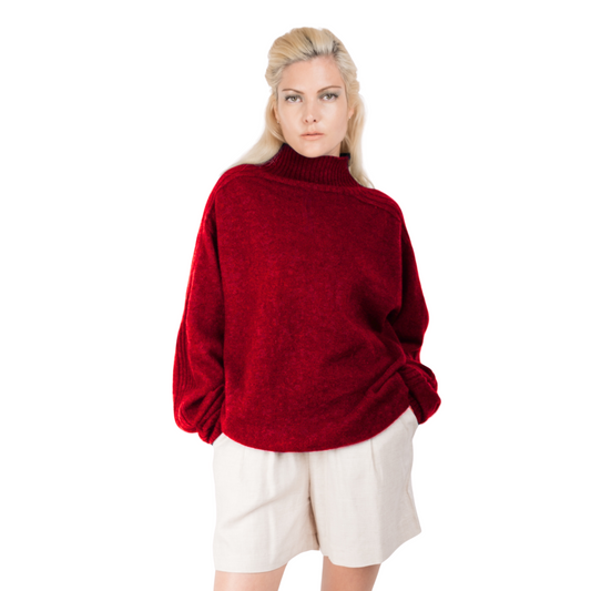 Blonde Woman wearing a red oversize turtleneck sweater made from Merino possum and Nylon. Jumper made in New Zealand by a female designer