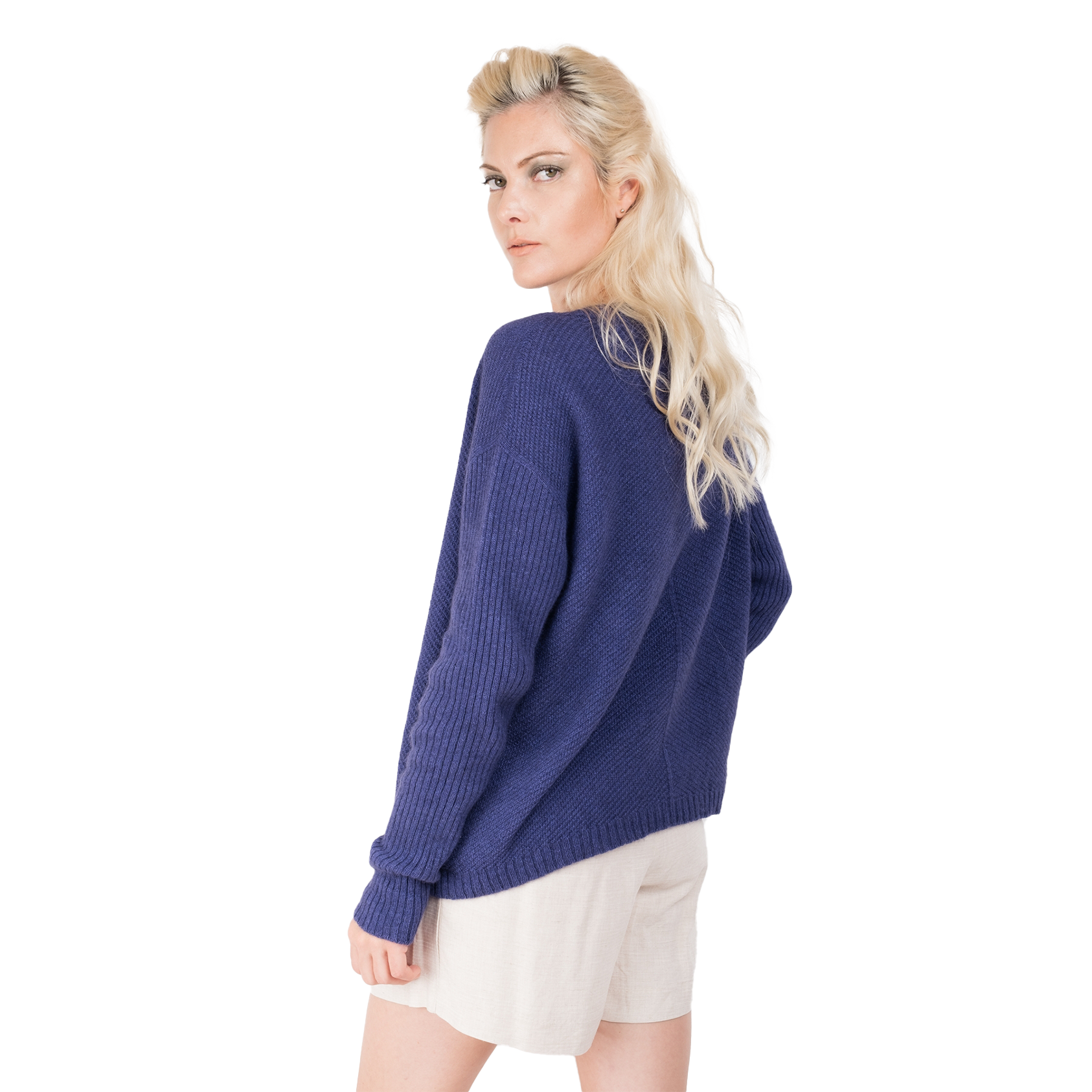 Blonde lady wearing a purple cashmere possum silk sweater. It has long ribbed sleeves and rib angled detail knitted on the body. Made in New zealand.