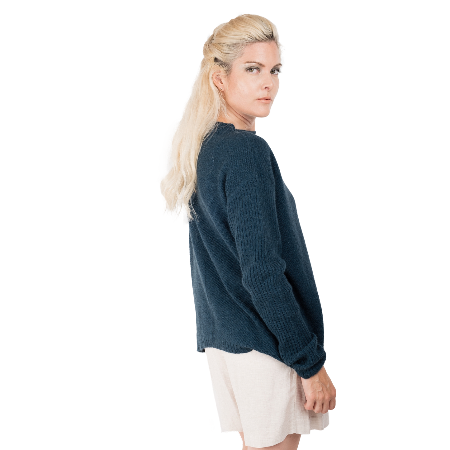 Blonde lady wearing a ocean teal blue cashmere possum silk sweater. It has long ribbed sleeves and rib angled detail knitted on the body. Made in New zealand.