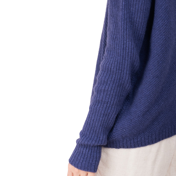 detail view of ribbed hem cashmere possum silk knitted sweater in an purple, made in new zealand. Ribbed angled lines don the body of the sweater and long ribbed sleeves