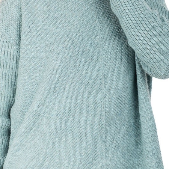 detail view of a cashmere possum silk knitted sweater in a pale ocean blue, made in new zealand. Ribbed angled lines on the body of the sweater and long ribbed sleeves