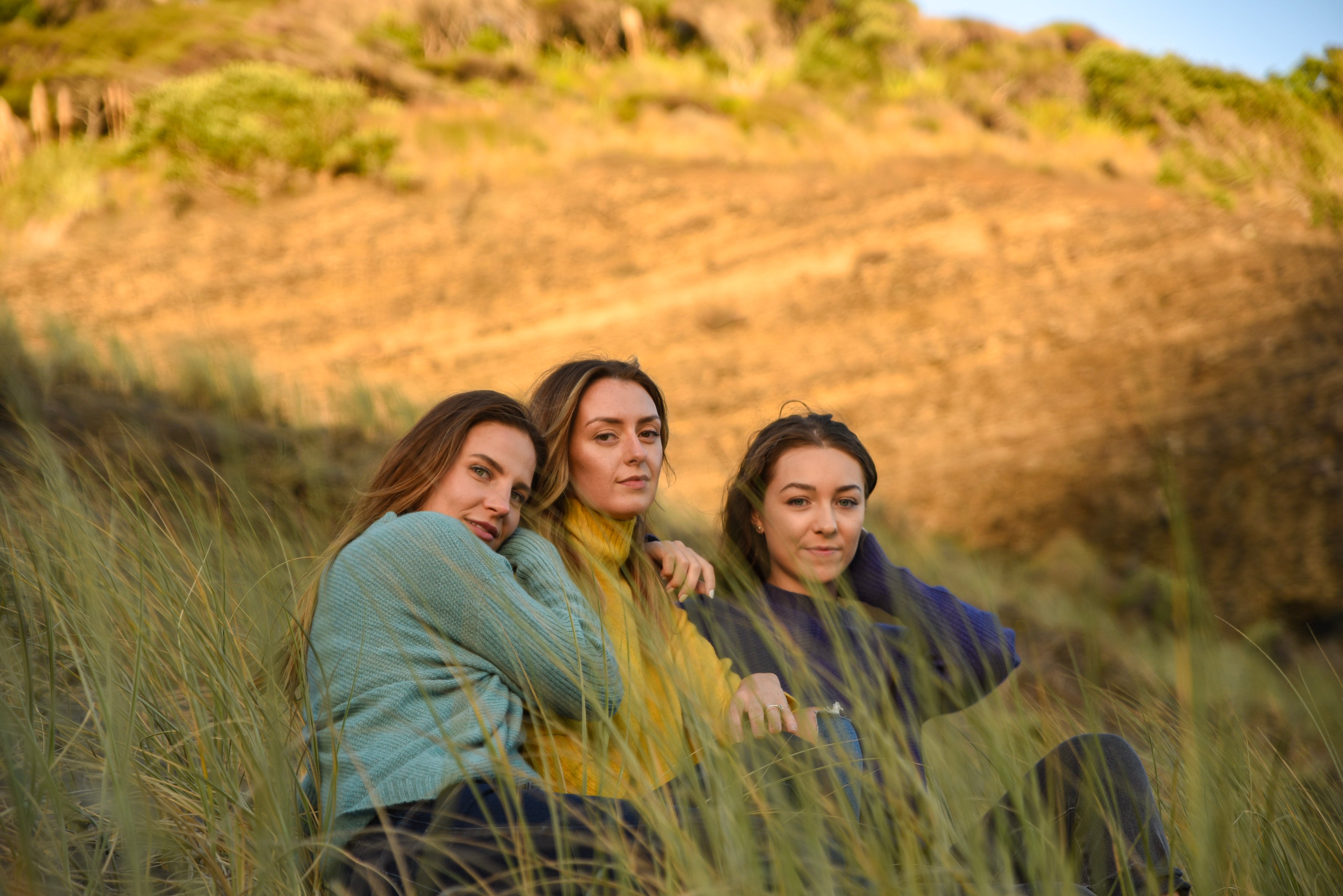 100% Natural cashmere sweaters worn by three woman in the dunes of the beach