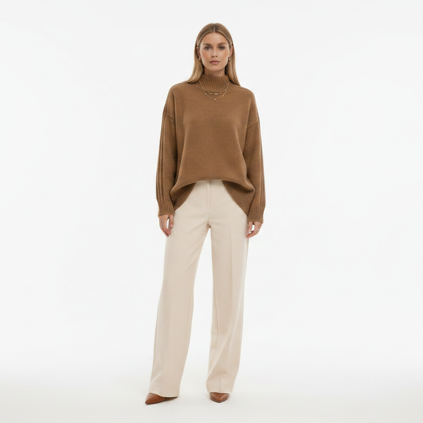 Woman wearing a brown sweater and beige pants on a white background