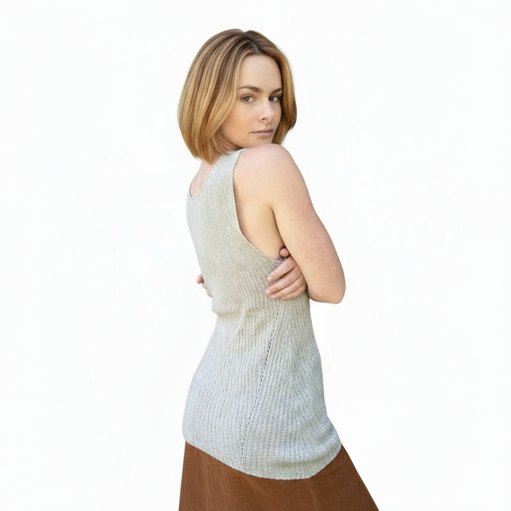 Woman wearing a light-colored sleeveless top and brown skirt on a white background