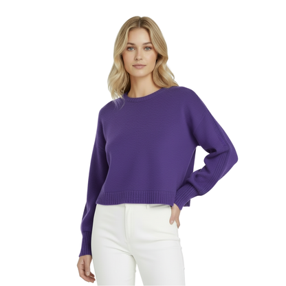 Woman wearing a purple sweater and white pants on a white background