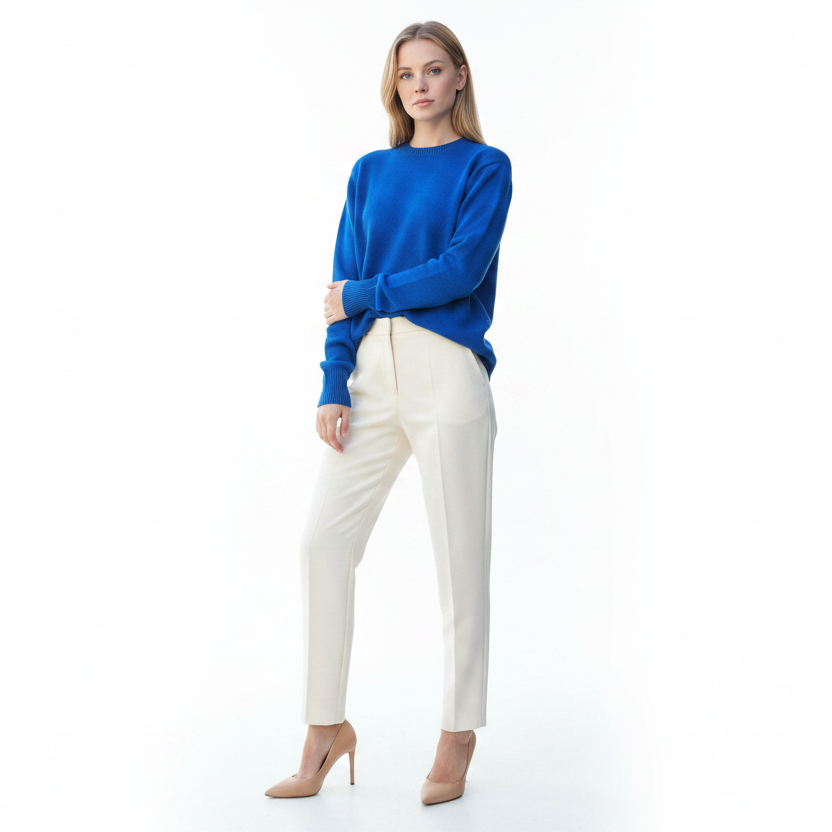 Woman wearing a blue sweater and white pants on a white background