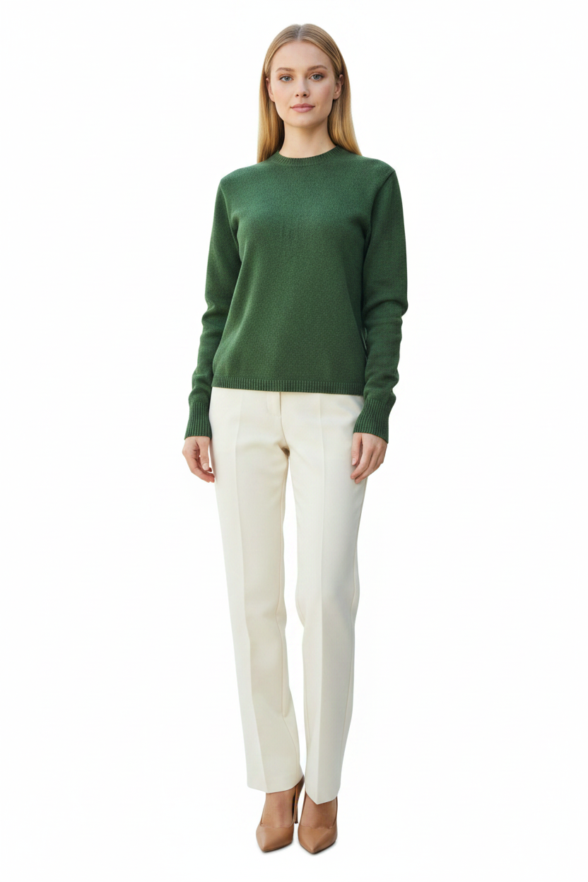 Woman wearing a green sweater and white pants on a white background
