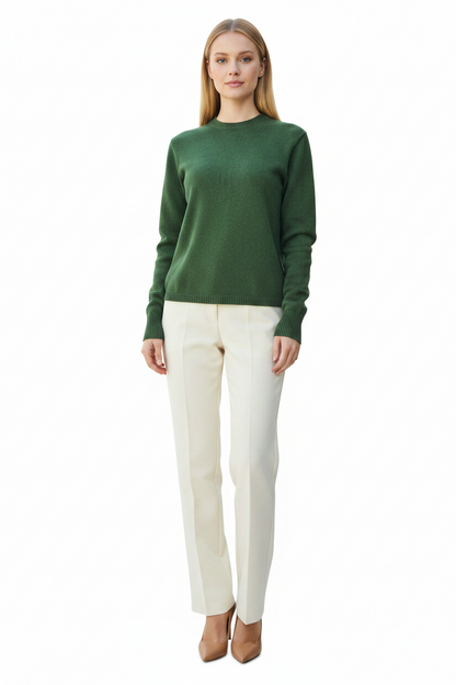 Woman wearing a green sweater and white pants on a white background