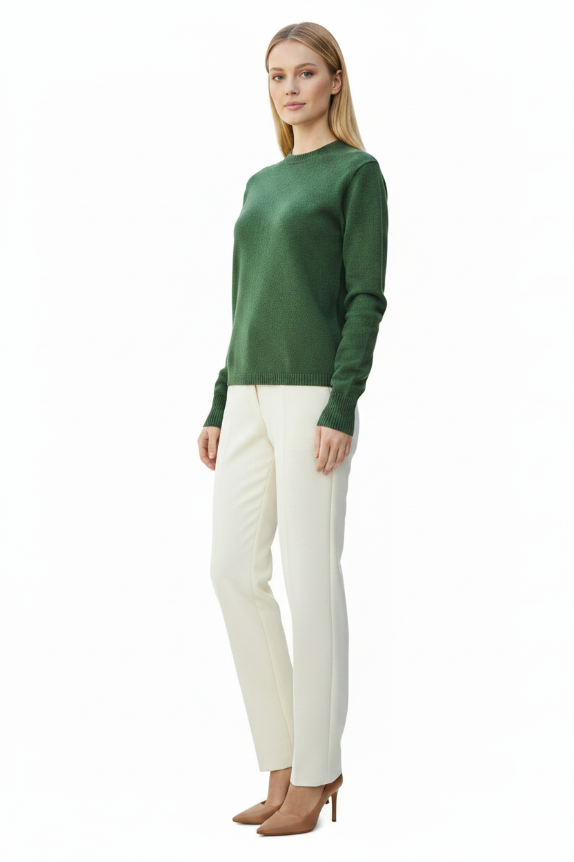 Woman wearing a green sweater and white pants on a white background