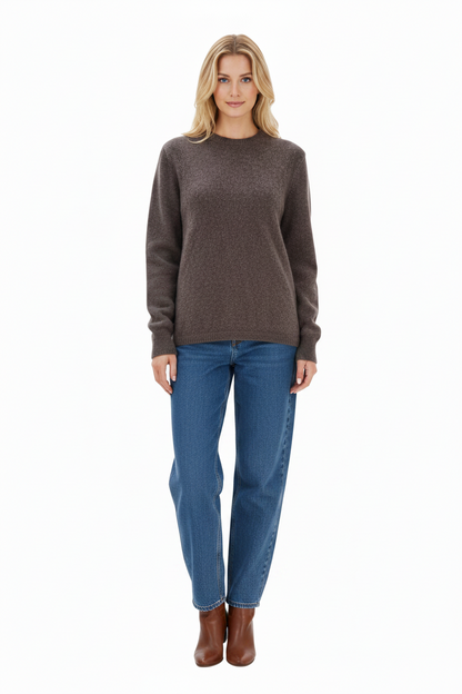Woman wearing a brown sweater and blue jeans on a white background