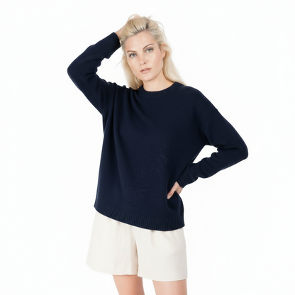 Woman wearing a navy sweater and white shorts on a white background