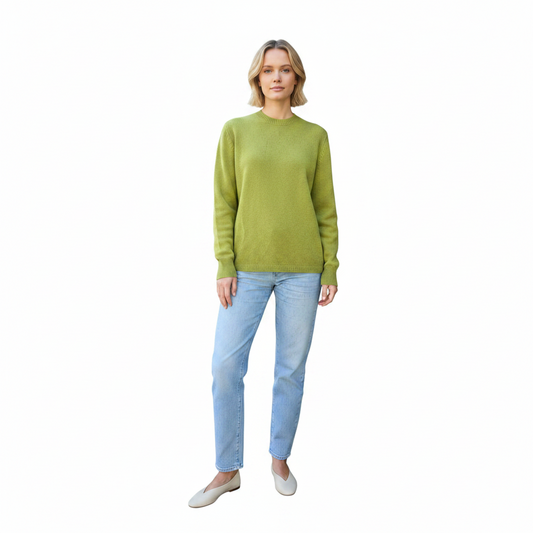 Woman wearing a green sweater and light blue jeans on a white background