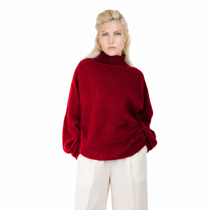 Person wearing a red sweater and white pants on a white background