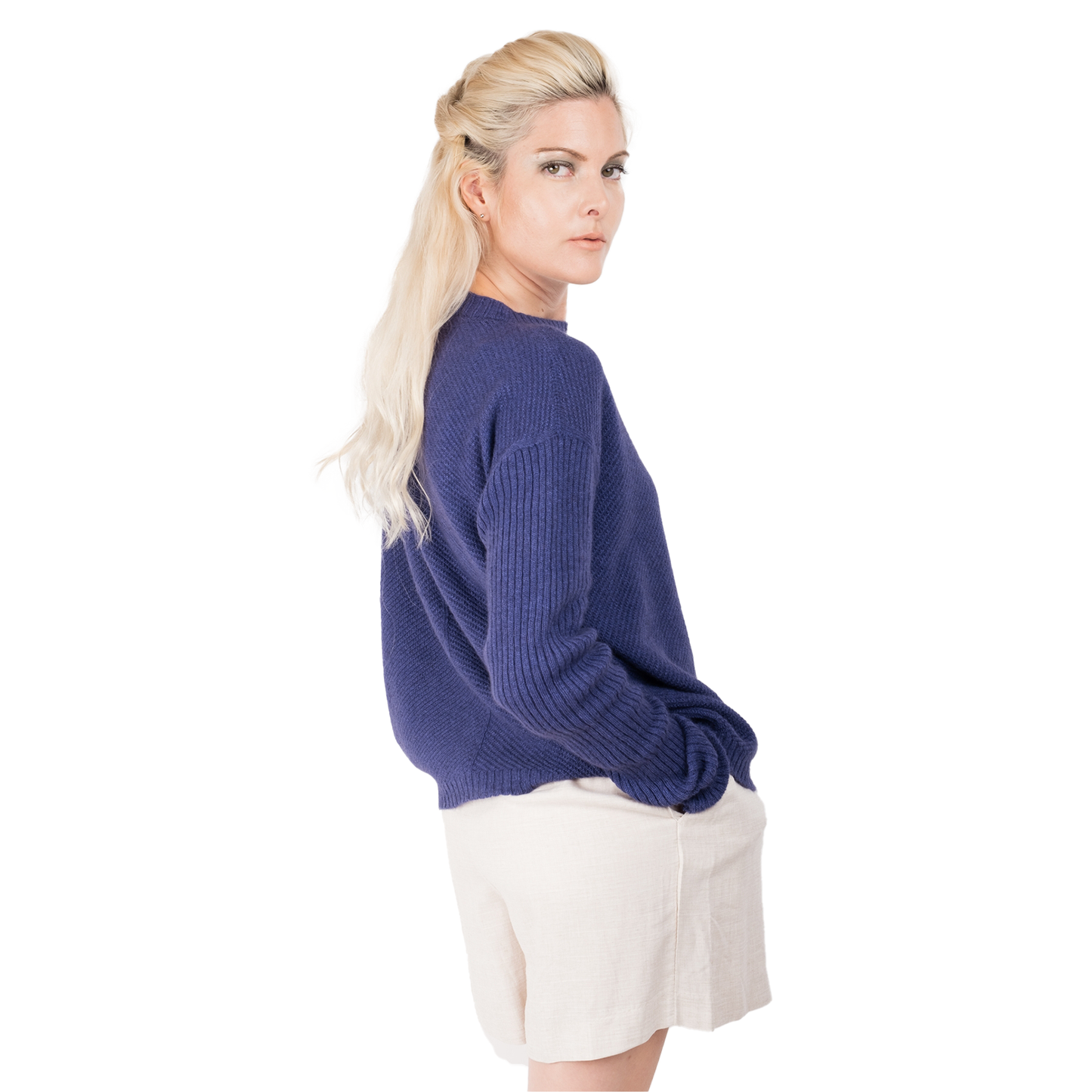 Blonde lady wearing a purple cashmere possum silk sweater. It has long ribbed sleeves and rib angled detail knitted on the body. Made in New zealand. 