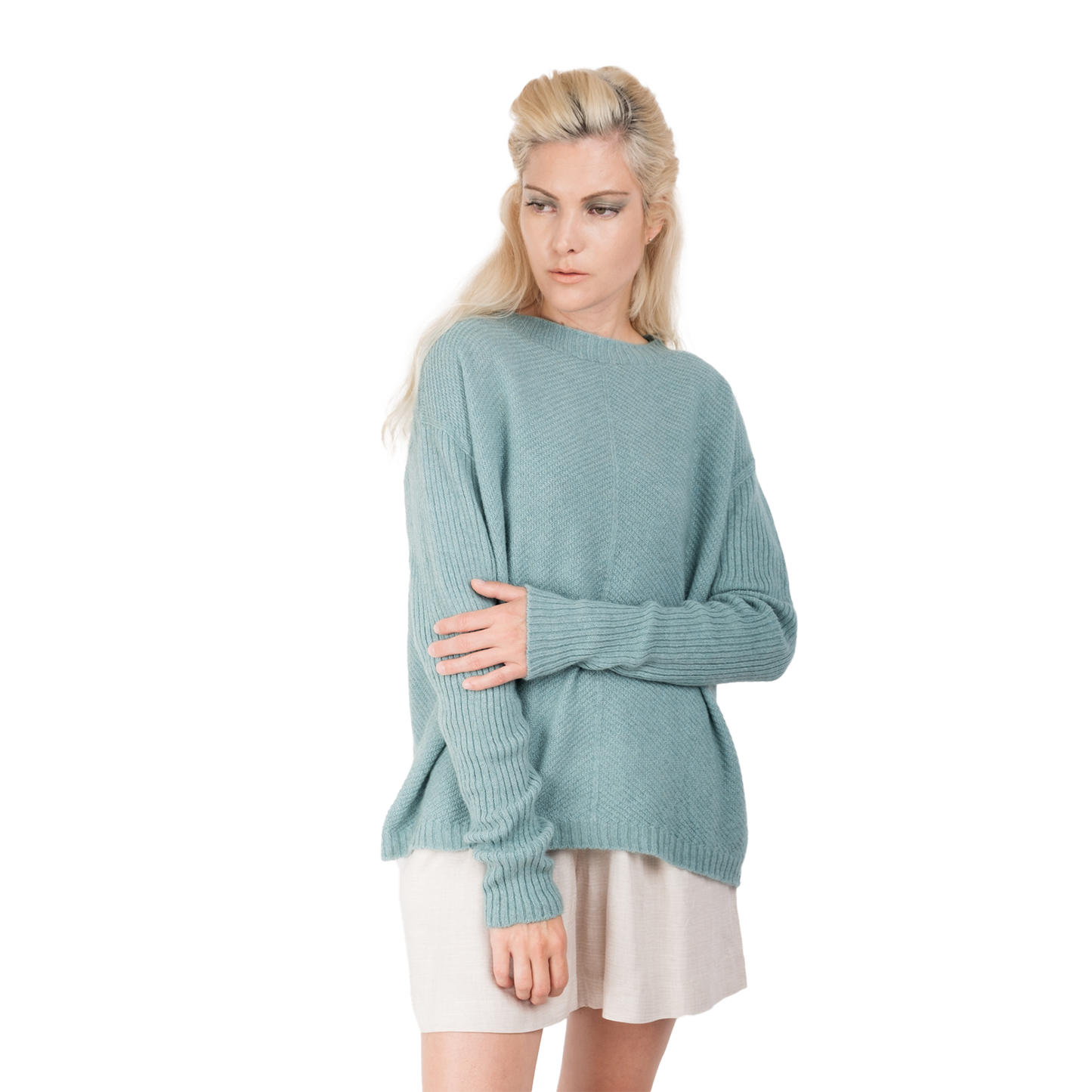 Blonde lady wearing a pale ocean blue cashmere possum silk sweater. It has long ribbed sleeves and rib angled detail knitted on the body. Made in New zealand. 