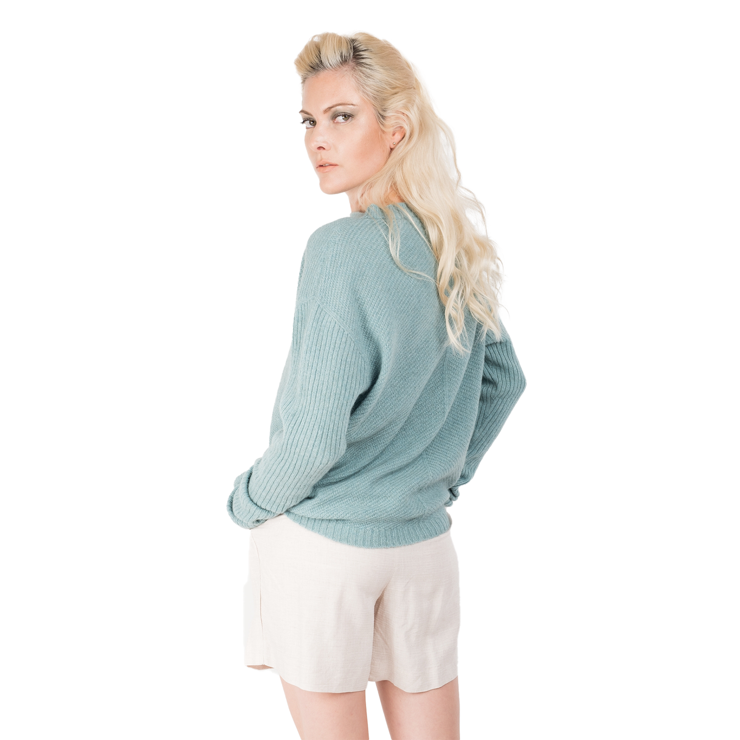 Blonde lady wearing a pale ocean blue cashmere possum silk sweater. It has long ribbed sleeves and rib angled detail knitted on the body. Made in New zealand. 